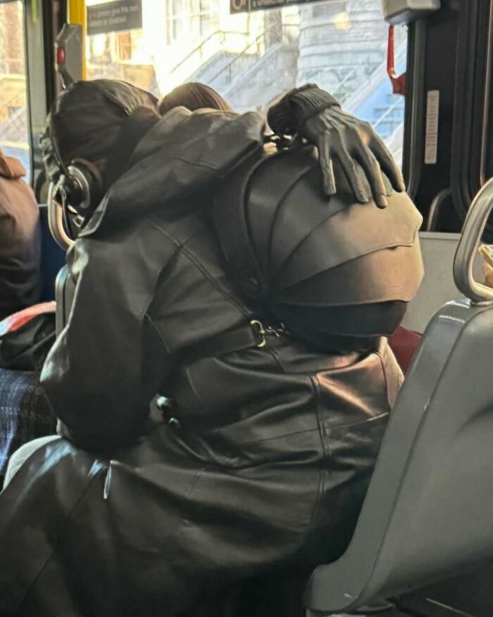 NYC locals in all-black, experimental fashion, embracing on a bus.