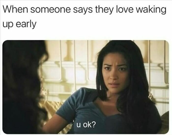 Woman in bed with a skeptical expression, reacting to someone claiming they love waking up early; humor for women.