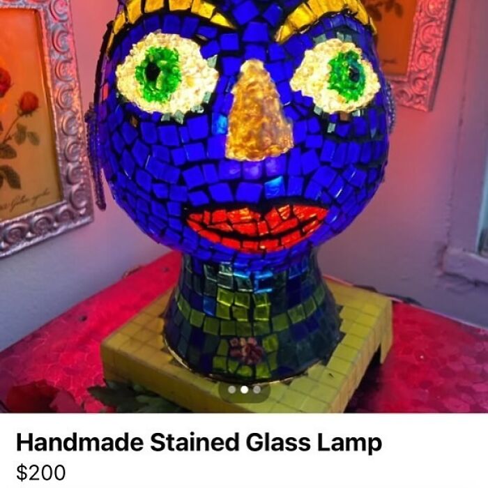 Handmade stained glass lamp with vibrant colors, showcasing an abstract face design, listed for $200 on Facebook Marketplace.