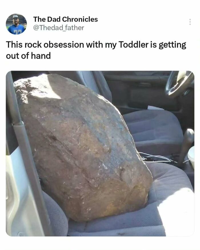 A large rock humorously placed on a car seat, showcasing the daily joys and struggles of a dad.