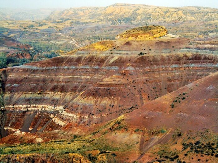 Stunning natural phenomena of colorful layered hills in a rugged landscape.