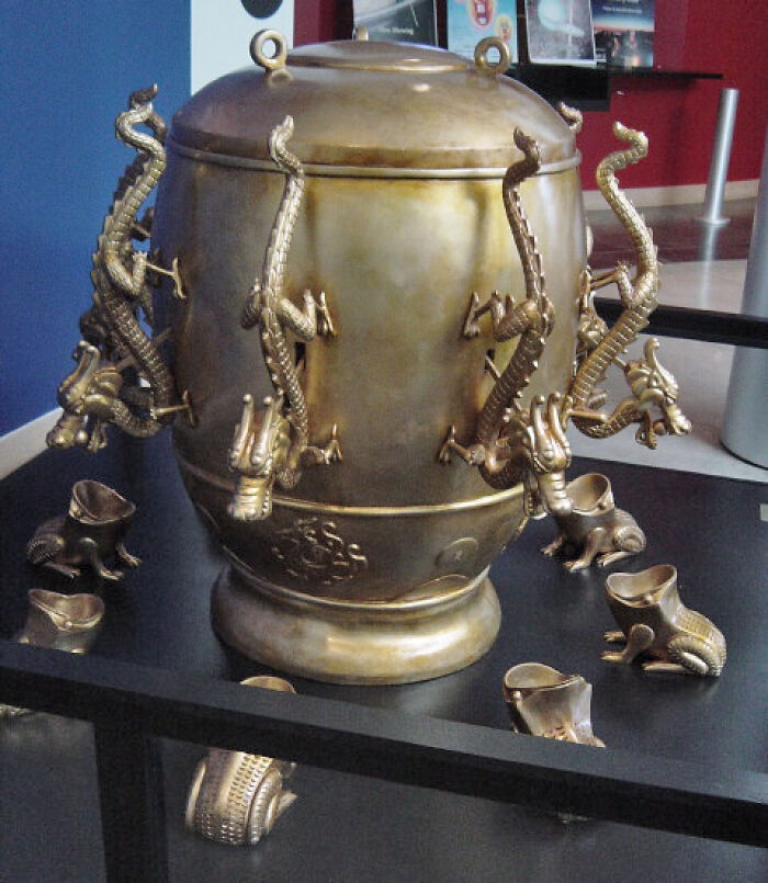 Historical invention depicting ancient Chinese seismograph with ornate dragon design on display.