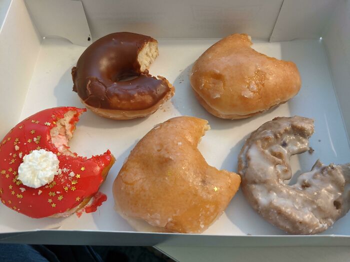 A box of assorted donuts with bites taken out, symbolizing people quitting jobs.