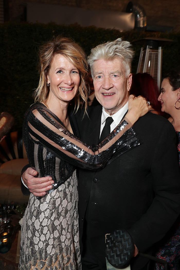 Laura Dern and David Lynch smiling at an event, wearing formal attire.