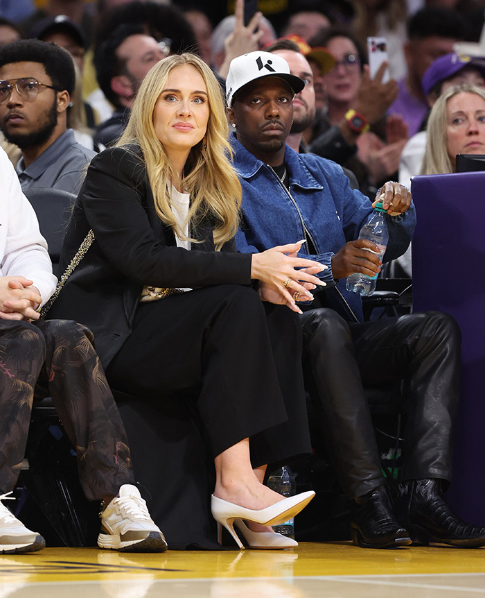 Adele with fiancé Rich Paul at a basketball game, sparking pregnancy speculation.