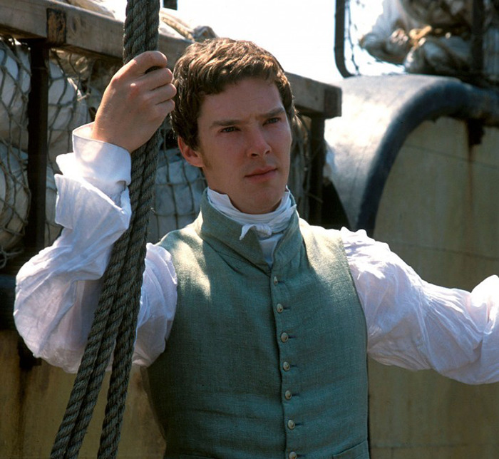 Benedict Cumberbatch in a ship setting, holding a rope and wearing period clothing on a scene from 'To the Ends of the Earth.