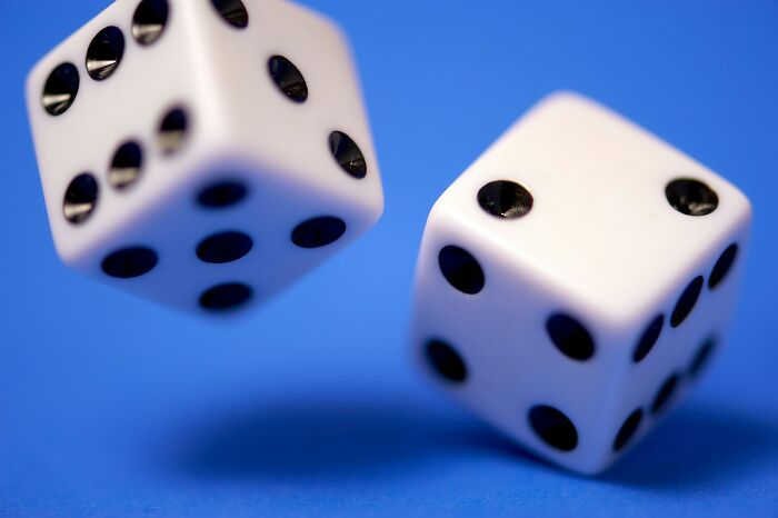 White dice with black dots on a blue background, representing classic games.