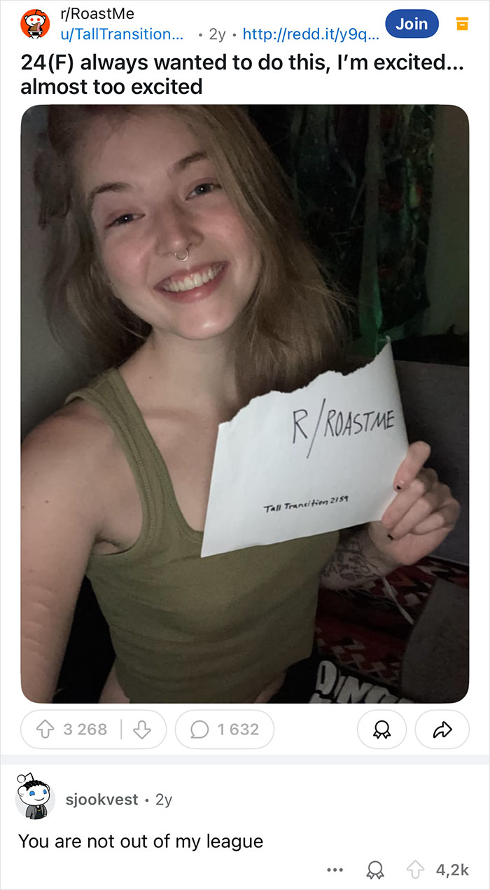 Smiling person holding a "Roast Me" sign, humorously participating in comeback challenge.