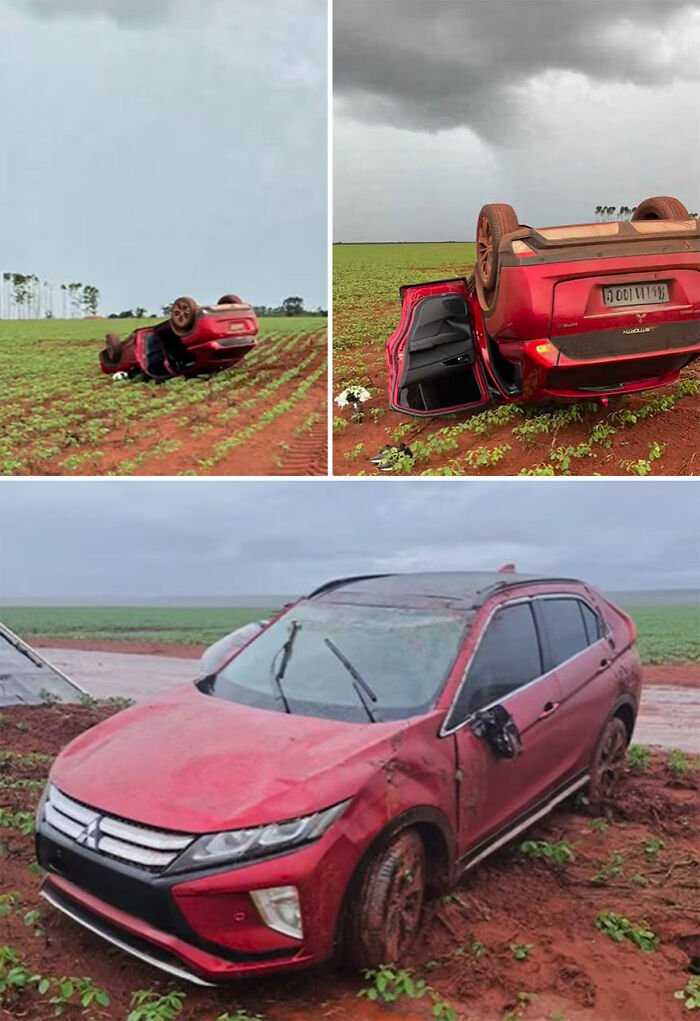 Overturned red car on a dirt field, capturing the scene of an accident.