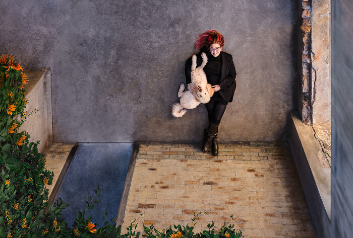 Woman with a plush dog on a patio, part of the International Pet Photographer Awards 2024 showcase.