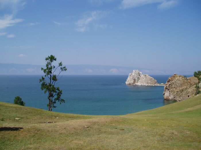 A stunning natural phenomenon of a rocky island in a vast blue lake under a clear sky.