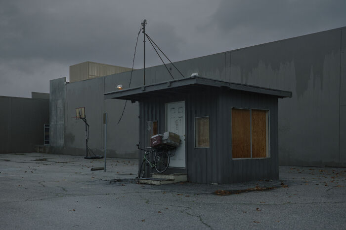 Small suburban structure with a bicycle, reflecting quiet suburban disconnection.