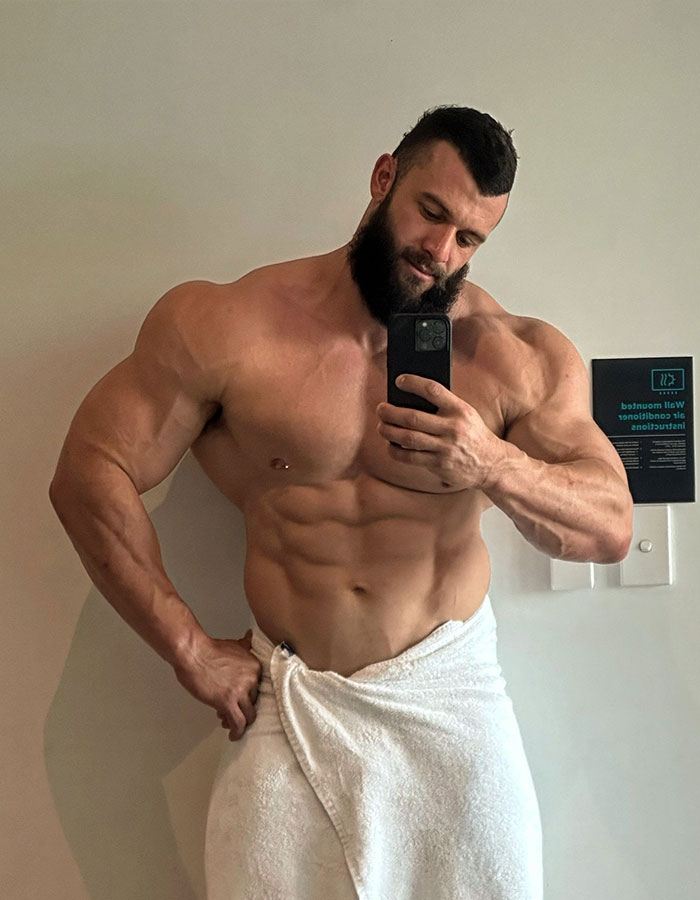 Muscular male stripper taking a selfie in a towel, illustrating bachelorette party experiences.