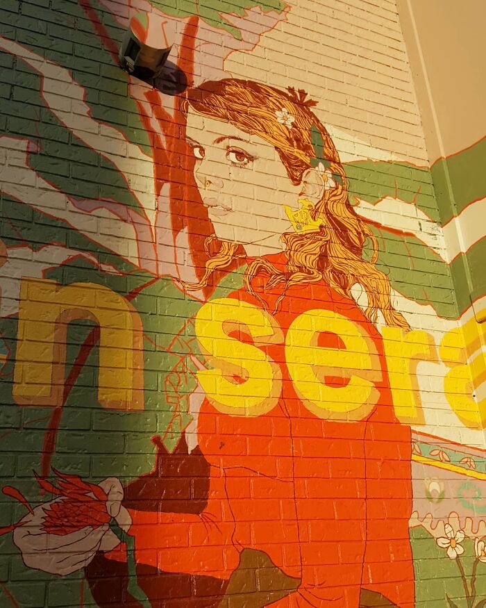 Bright Montréal mural featuring a woman in red with floral accents and bold yellow letters.