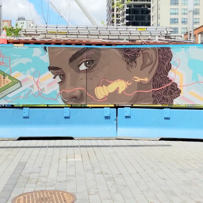 Montréal artist's mural featuring a detailed portrait and vibrant colors on an urban wall.