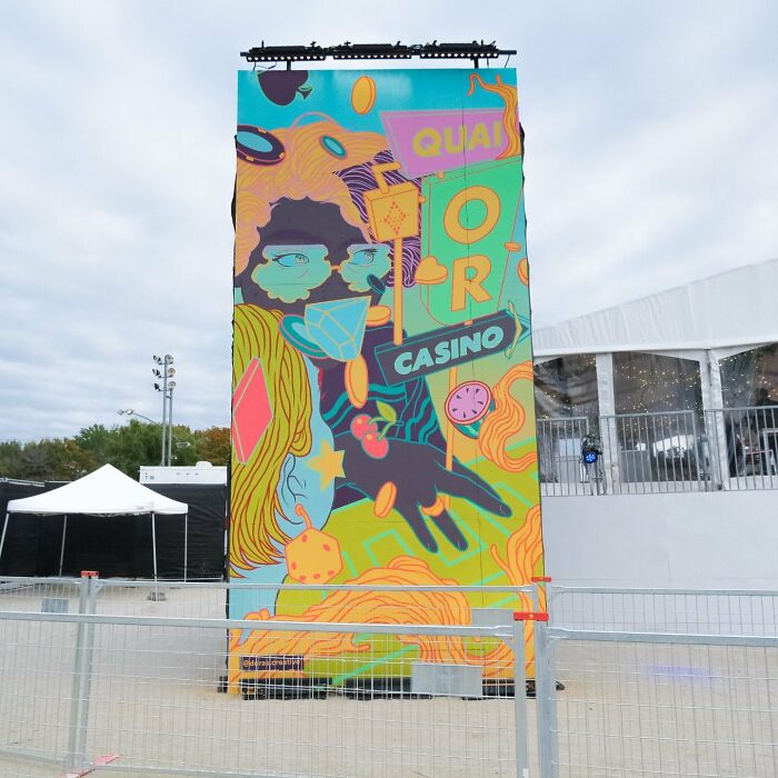 Colorful mural by Montréal artist transforms tall wall into vibrant artwork at outdoor venue.