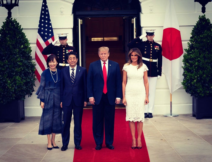 Freelance magician at White House event with officials on a red carpet, featuring military guards and national flags.