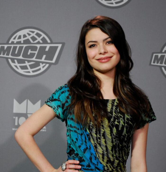 Smiling woman in patterned dress at event, embodying intriguing facts from an explore community.