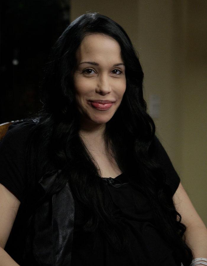 Octomom Nadya Suleman in an interview, wearing a black shirt and smiling.