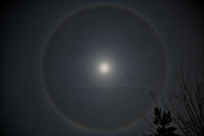 A glowing halo around the moon in a dark sky, illustrating a stunning natural phenomenon.