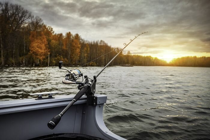 Fishing rod on a boat during sunset, ideal for packing for your boat trip.