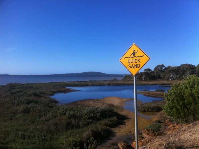 Quicksand warning sign near a wetland, showcasing the stunning natural phenomena of the area.