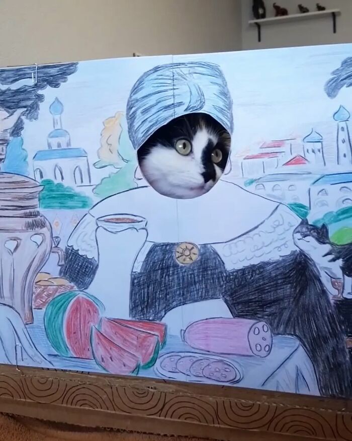 Rescue cat posing as living art in a painted costume scene.