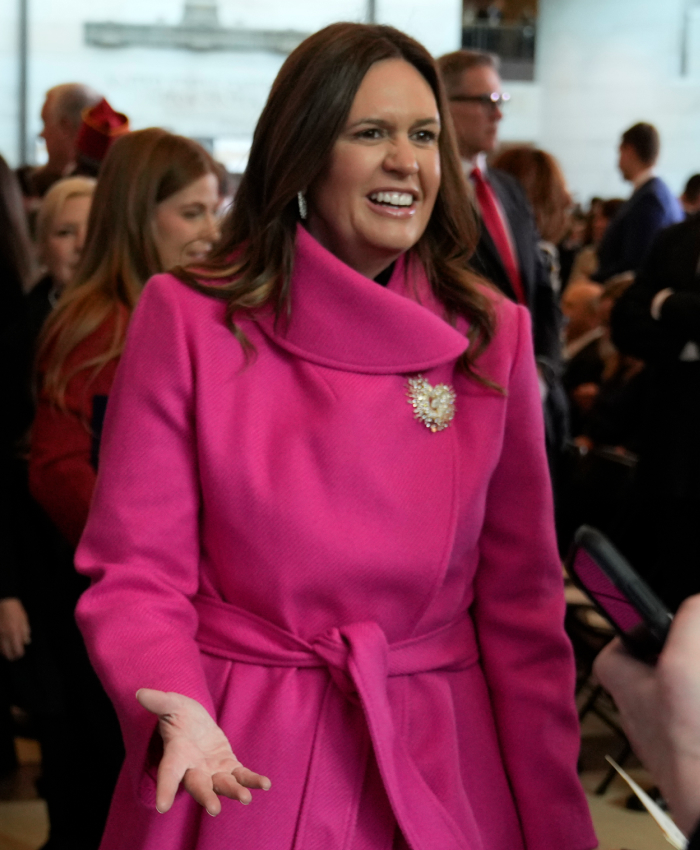 Person in a bright pink coat at a presidential inauguration event, in a crowd setting, related to controversial outfits.