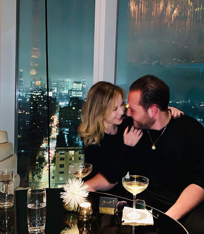 A couple enjoying drinks with a cityscape view, linked to School of Rock stars reuniting.