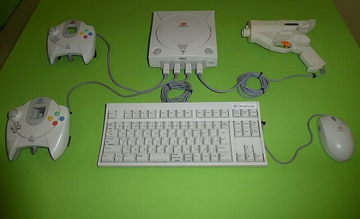 Vintage gaming console with accessories on a green background, featuring historical inventions ahead of their era.