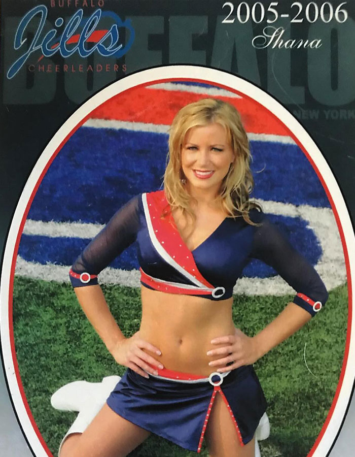 Buffalo Bills cheerleader in a uniform poses on the field with hands on hips, highlighting cheer squad's past rules.