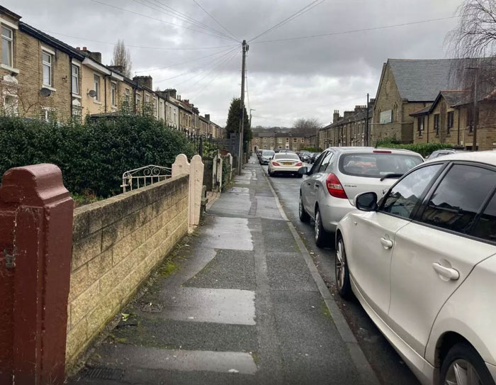 Residential street view with parked cars, cloudy sky, wet pavement; associated with arranged marriage bride case.