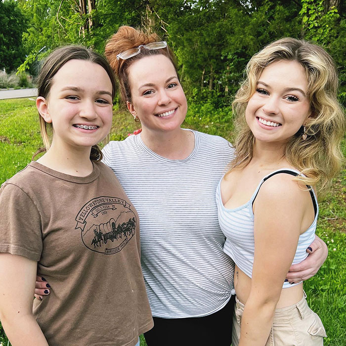 Mother and two daughters smiling outdoors, related to 'Side-Eyeing Chloe' meme.