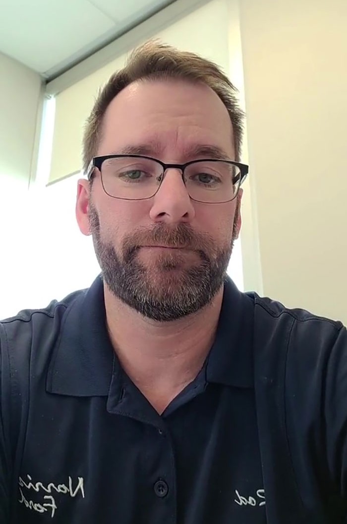 Canadian dad shares golden rulebook on lottery wins, wearing glasses and a dark shirt in a bright room.