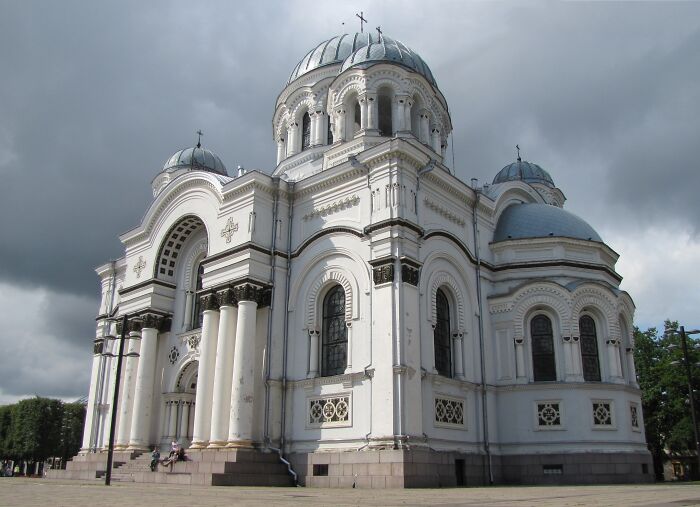 Stunning white church with intricate architecture under a cloudy sky.