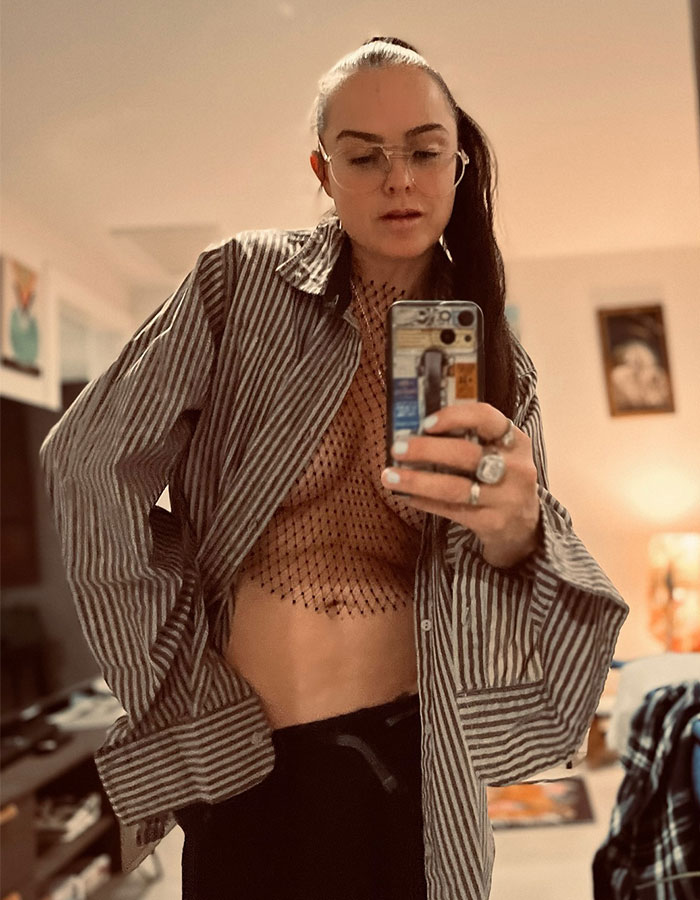 Actress takes mirror selfie in a striped shirt and glasses, sparking concern among fans.