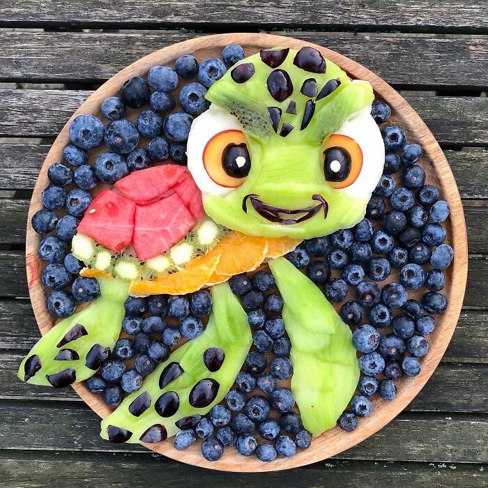 Fruit turtle art made from watermelon, kiwi, oranges, and blueberries, showcasing healthy eating creativity.