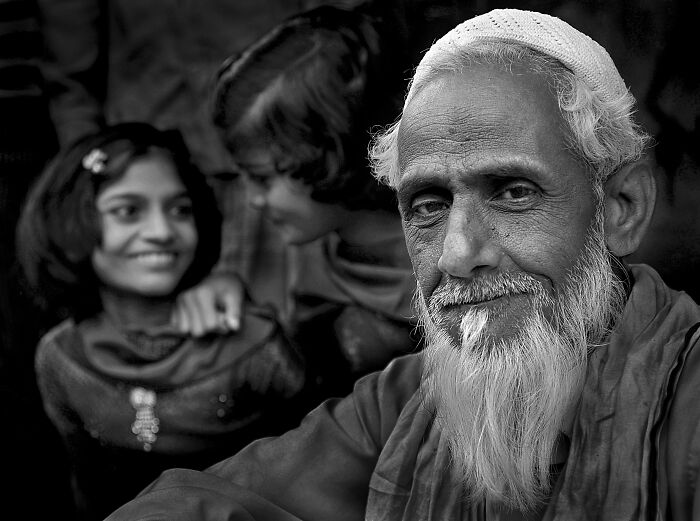 Elderly man with a white beard and children, capturing resilience and beauty of everyday people, by Istvan Kerekes.