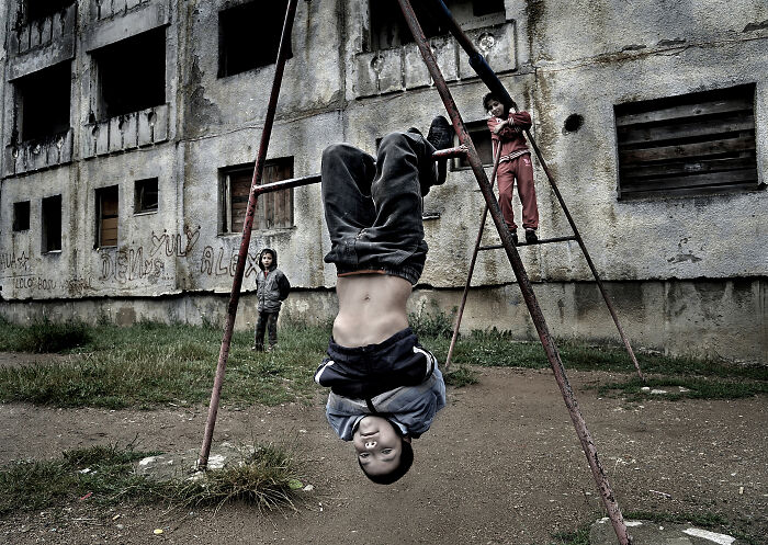 Children playing on swings in an urban setting, showcasing the resilience and beauty of everyday people.