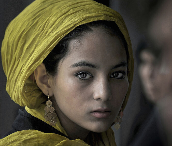 A young person with a yellow headscarf, captured by Istvan Kerekes, embodies resilience and beauty in everyday life.