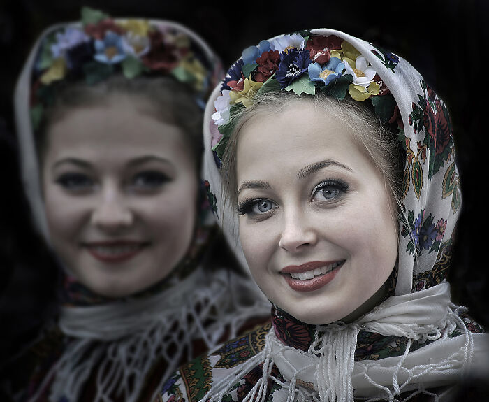 Two women in colorful floral scarves, smiling warmly, illustrating the resilience and beauty of everyday people.