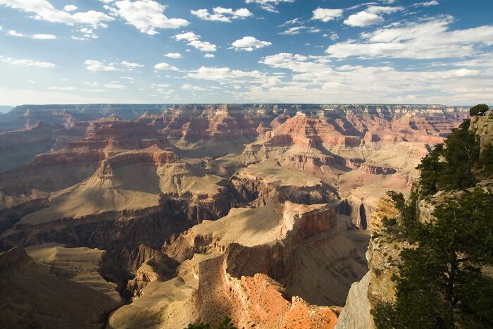 Grand Canyon landscape showcasing stunning natural phenomena under a partly cloudy sky.