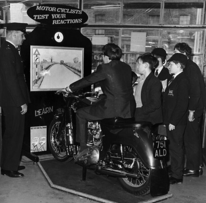 Vintage motorcycle reaction tester, a historical invention ahead of its time, being demonstrated to a group.