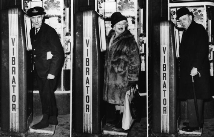 People using an early 20th-century vibration machine, showcasing historical inventions.