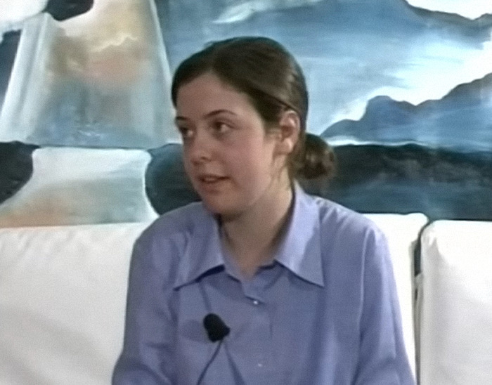 Young woman speaking, wearing a blue shirt, with a painting in the background; related to "Wild Child" actress turned nun.