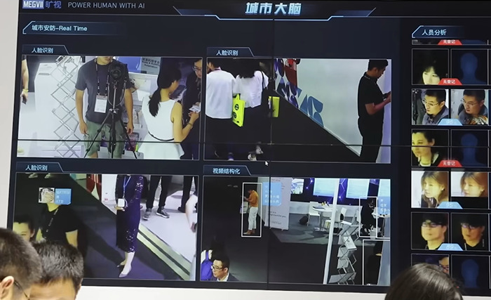 Chinese-Canadian highlights surveillance screen showcasing facial recognition and AI technology in China.