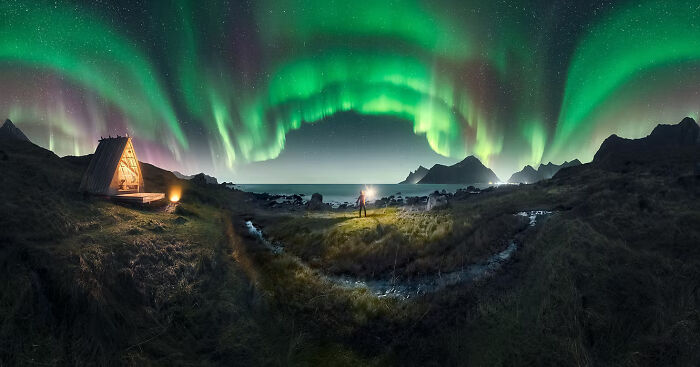 Aurora borealis over a small cabin by the sea, one of the Artist Gallery Awards winning photos.