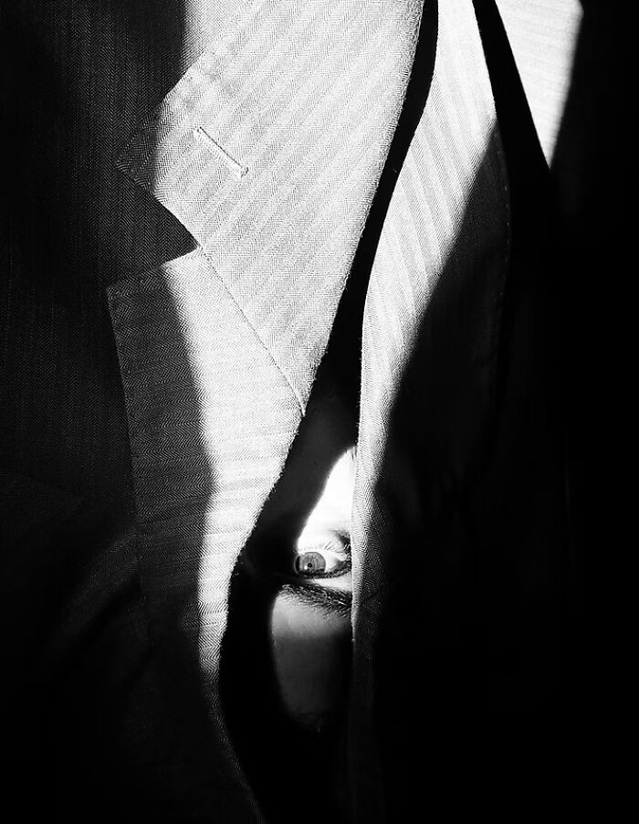 A striking black and white photo of an eye peeking through fabric at The Artist Gallery Awards.