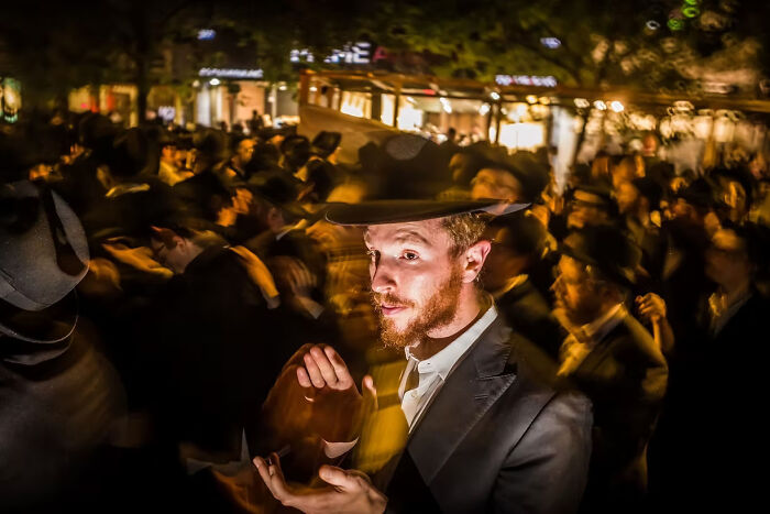 Man in a crowd wearing a hat, captured in motion; a winning photo from The Artist Gallery Awards.