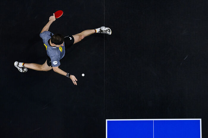 Overhead shot of a table tennis player in action, capturing a dynamic pose, from the World Sports Photography Award.